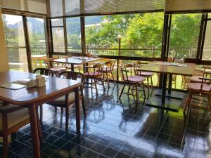 - un restaurant avec des tables et des chaises dans une salle dotée de fenêtres dans l'établissement Hotel Nikko-Kinugawa Inn Miyasaki, à Nikkō