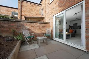 zwei Stühle auf einer Terrasse neben einer Ziegelwand in der Unterkunft Crewe Short Lets 8 Victoria Court, Crewe in Crewe