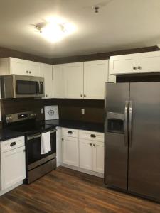 a kitchen with white cabinets and a stainless steel refrigerator at Vacation Bliss LLC in Hilton Head Island