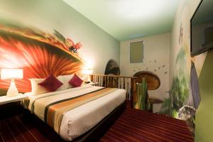 1 dormitorio con 1 cama con una pintura en la pared en Maison Boutique Theme Hotel Kuala Lumpur by Swing & Pillows, en Kuala Lumpur