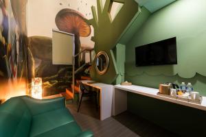 a room with a green wall with a desk and a tv at Maison Boutique Theme Hotel @ Bukit Bintang City Centre in Kuala Lumpur