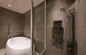 a bathroom with a shower and a toilet in it at Hotel Nikko Kanazawa in Kanazawa