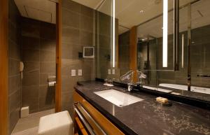 a bathroom with a sink and a large mirror at Hotel Nikko Kanazawa in Kanazawa