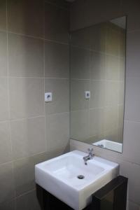 y baño con lavabo blanco y espejo. en Hotel Grand Karawang Indah, en Karawang