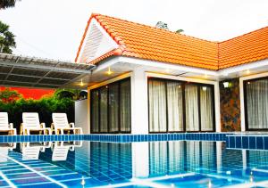 een huis met stoelen en een zwembad bij Baan Golden Pool Villa in Sam Roi Yot