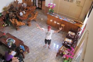 a man standing in a living room with his arms outstretched at Villa Pink House in Da Lat