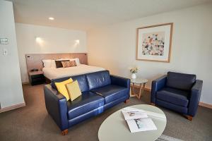 a bedroom with a bed and a couch and a table at Salamanca Inn in Hobart