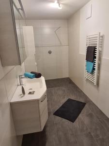 a white bathroom with a sink and a shower at Apart Kathrin in Fliess +28 photos