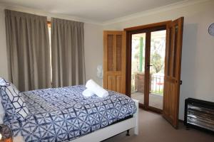 1 dormitorio con 1 cama y puerta corredera de cristal en Highland View, en Mount Victoria