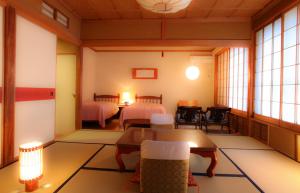 a room with two beds and a table and chairs at Yudanaka Yumoto in Yamanouchi