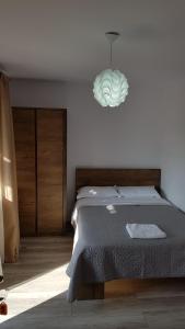 a bedroom with a bed and a pendant light at Casa Alesia Bucovina in Gura Humorului