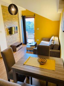 een woonkamer met een tafel en een bank bij Apartmani borova 2 in Veliko Gradište