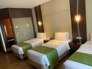 大雅台的住宿－Hotel Monticello Tagaytay，酒店客房,设有三张床和镜子