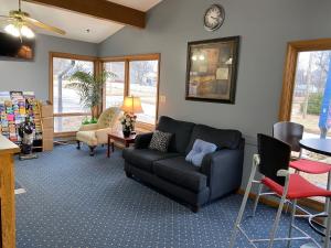 sala de estar con sofá negro y sillas en Diamond Motel - Abilene, en Abilene