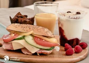 a sandwich on a plate next to a glass of milk at Prudentia Apartments Kłobucka in Warsaw