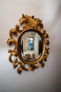 a gold mirror hanging on a wall at Capitol Hotel in Bucharest