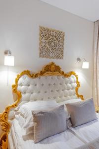 a bed with a white comforter and pillows at Capitol Hotel in Bucharest