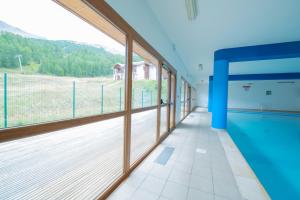 a large room with a swimming pool and large windows at Les Terrasses du Soleil d'Or By Infini Mountain in Les Orres