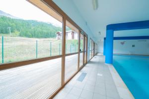 Cette grande chambre dispose d'une piscine et de grandes fenêtres. dans l'établissement Les Terrasses du Soleil d'Or By Infini Mountain, aux Orres