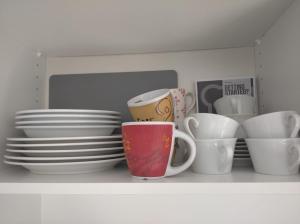 a shelf filled with plates and cups and bowls at Terrasse de Malmedy Malmedy nature 338 in Malmedy +17 photos