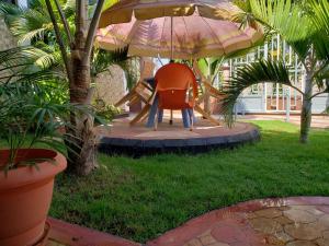un parco giochi con una sedia arancione sotto un ombrellone di Dodoma Siesta Inn a Dodoma