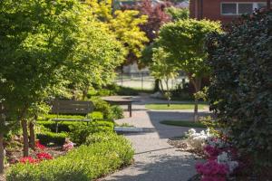 a park with a bench and flowers and trees at Forrest Hotel & Apartments in Canberra