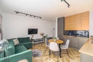 ein Wohnzimmer mit einer grünen Couch und einem Tisch in der Unterkunft Stylish Apartment Balticus 15 with Air Conditioning by Noclegi Renters in Misdroy