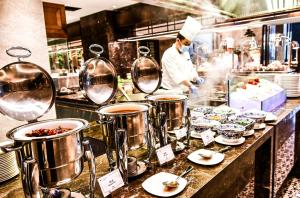 a chef preparing food in a restaurant kitchen at Pullman Yueyang in Yueyang