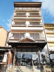 ein hohes weißes Gebäude mit vielen Fenstern in der Unterkunft Sakuraya in Miyajima