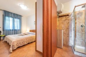 sypialnia z łóżkiem i prysznicem w obiekcie Villa Mallus 4 posti letto w mieście Olìa Speciosa