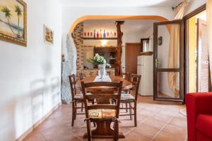 uma cozinha e sala de jantar com mesa e cadeiras em Villa Mallus 4 posti letto em Olìa Speciosa