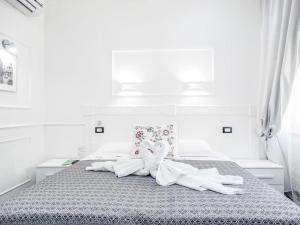 Un dormitorio blanco con una cama con un osito de peluche. en La Locanda di Piazza del Popolo, en Roma