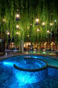 長崎的住宿－艾蘭長崎度假村，一座带树木和灯光的建筑中的热水浴缸