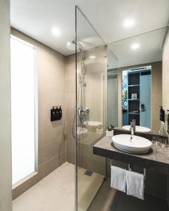a bathroom with a shower, sink, and mirror at MAMAKA by Ovolo in Kuta