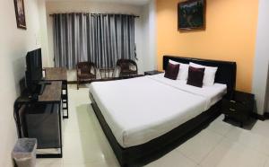 a bedroom with a bed and a television in it at ช้างเผือกเกสต์เฮ้าส์ Changphueak Guesthouse in Nan