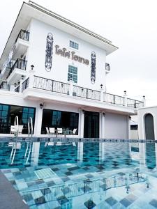 um hotel com piscina em frente a um edifício em โคโค่ โฮเทล KOCO Hotel em Nakhon Ratchasima