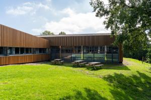 a building with benches in the grass in front of it at La Résidence du Parc d'Olhain in Maisnil-lès-Ruitz