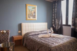 una camera da letto con un letto con un nastro sopra di Hotel Garda a Affi