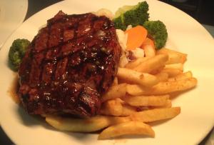 a plate of food with meat and fries and broccoli at Blackwater Hotel Motel in Blackwater