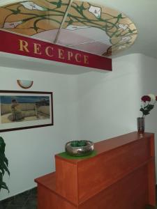 um sinal na parede por cima de uma cómoda num quarto em Wellness Hotel Haná em Mariánské Lázně