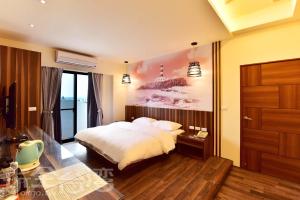 sypialnia z łóżkiem i obrazem na ścianie w obiekcie Yu B&B w mieście Wang-an
