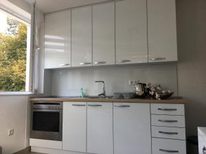 a kitchen with white cabinets and a sink and a window at Apartman “Centar Jajce “ in Jajce