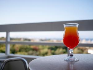 a glass of juice sitting on top of a table at Athineon Hotel in Rhodes Town