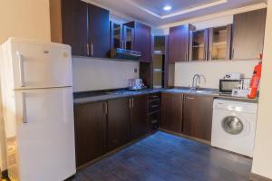 a kitchen with a white refrigerator and a washing machine at Ewan Ajman Suites Hotel in Ajman 