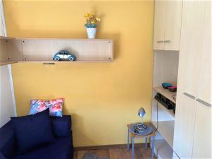 a living room with a blue couch and a yellow wall at Tiny House mit Klima und Heizung, in idyllischer Ortsrandlage in Iba