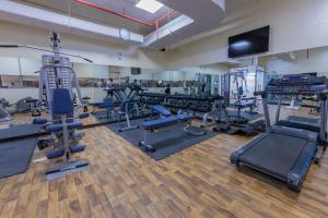 a gym with lots of treadmills and machines at Ewan Ajman Suites Hotel in Ajman 