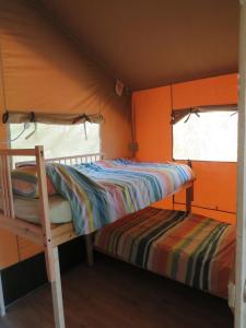 - une petite chambre avec des lits superposés et une fenêtre dans l'établissement Domaine Audubert, à Saint-Antonin