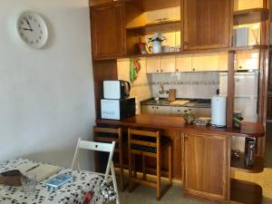 a kitchen with a counter and a clock on the wall at Apartamento Agaete Park in Playa del Ingles