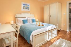 a bedroom with a large white bed with blue sheets at Sun Spalato Beach in Split