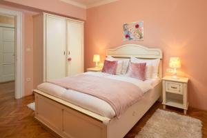 1 dormitorio con 1 cama grande y paredes de color rosa en Sun Spalato Beach en Split